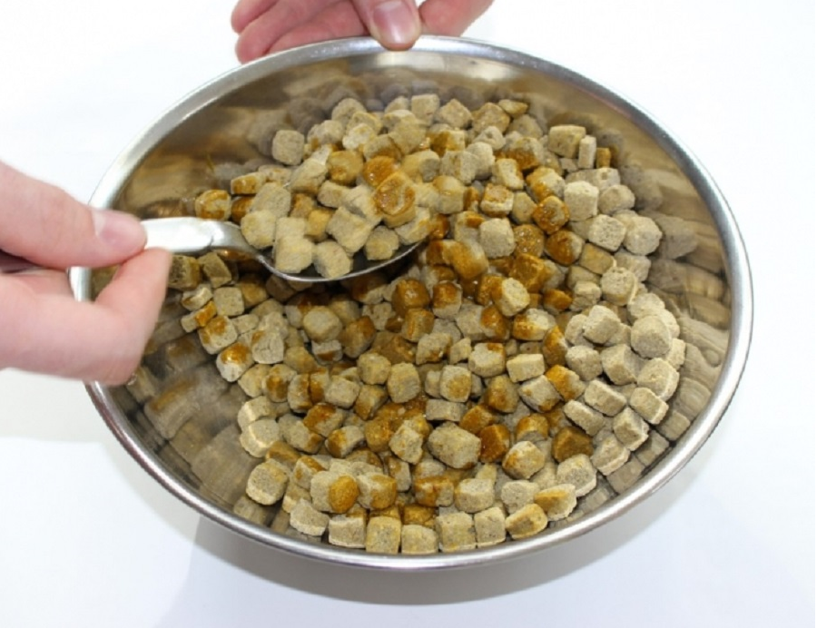 Palmgloss being mixed into a bowl of Harrison's Bird Foods coarse nuggets