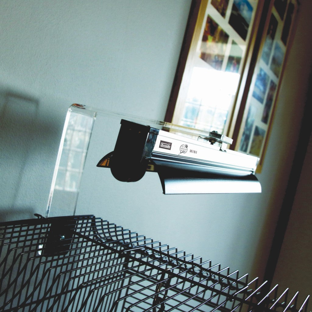An Arcadia PureSun Mini UVB lamp mounted over a bird's cage